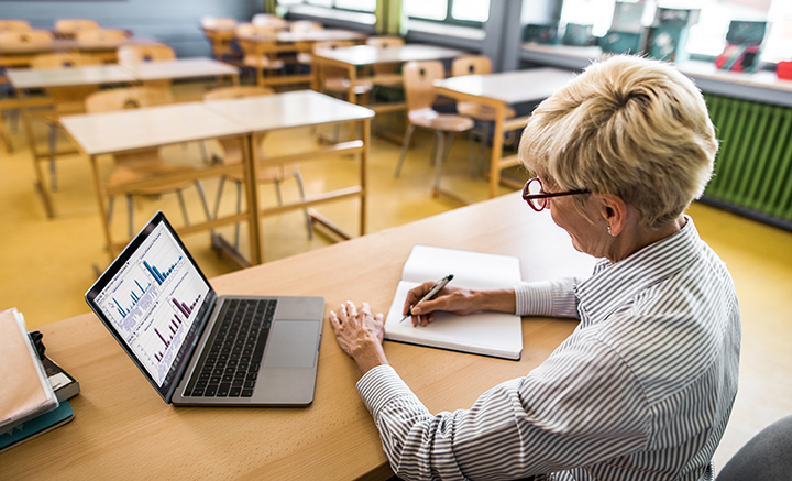 Teacher working at desk in classroom