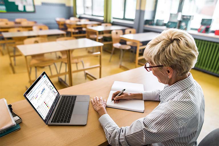 Teacher on a laptop reviewing student and district data